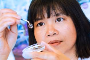 Professor May Griffith holding a synthetic cornea